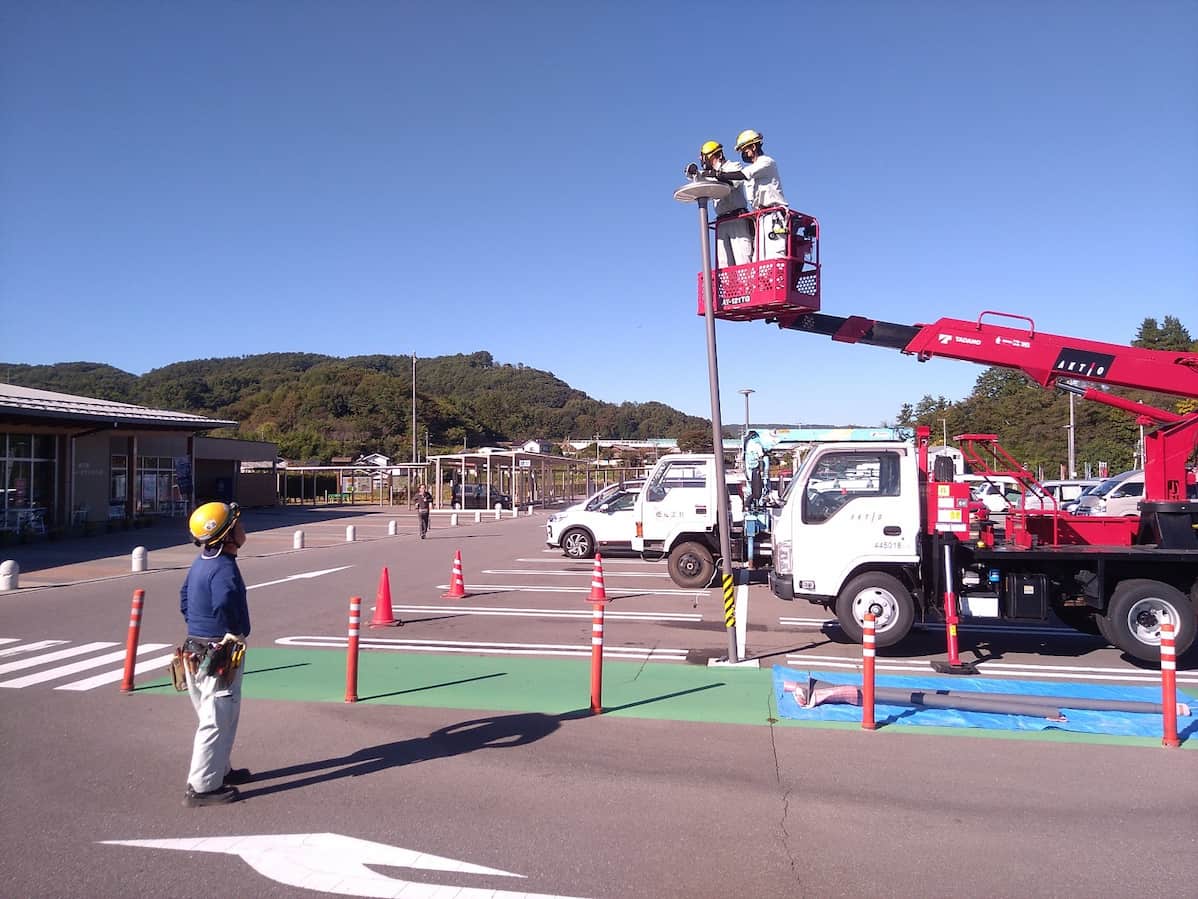 駐車場のスピーカーを高所作業車に乗って設置作業を行っています。